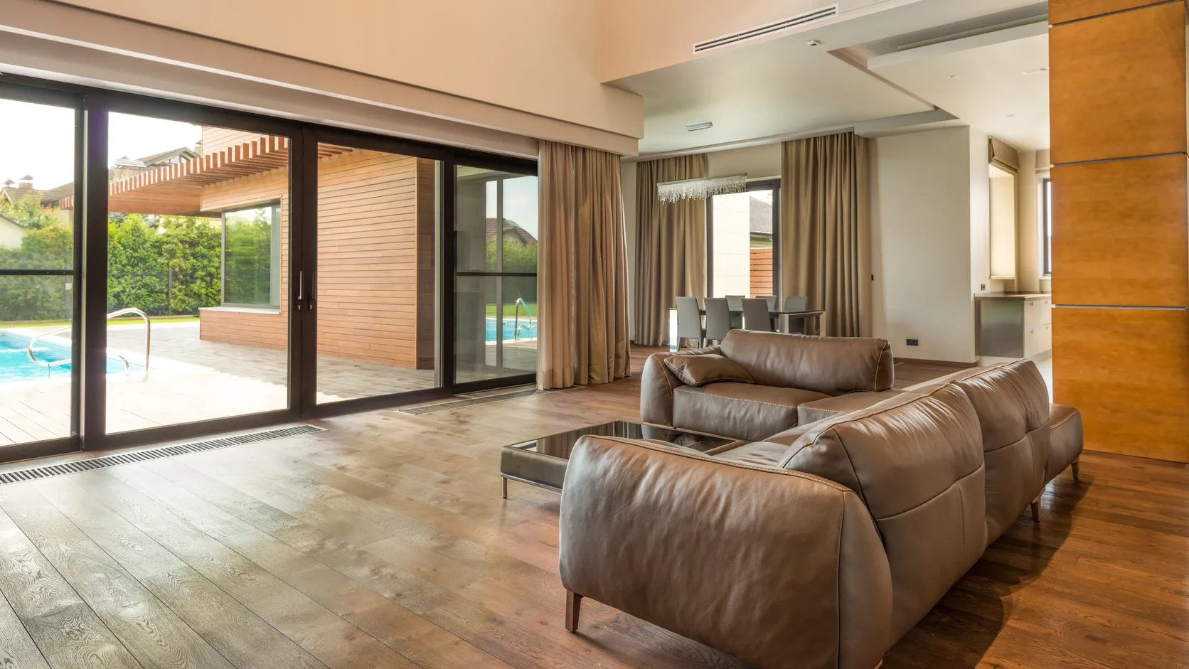 Modern sliding glass doors opening to a pool deck in a luxury home